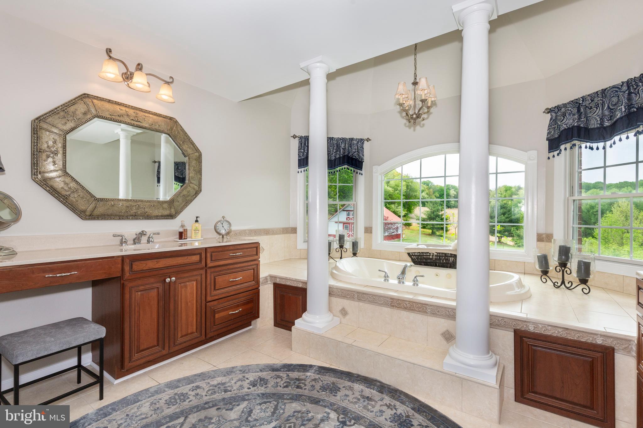 2995 Sams Creek Road New Windsor, MD 21776 - Photo 72 of 126 a spacious bathroom with a double vanity sink a two mirror a window and a bathtub