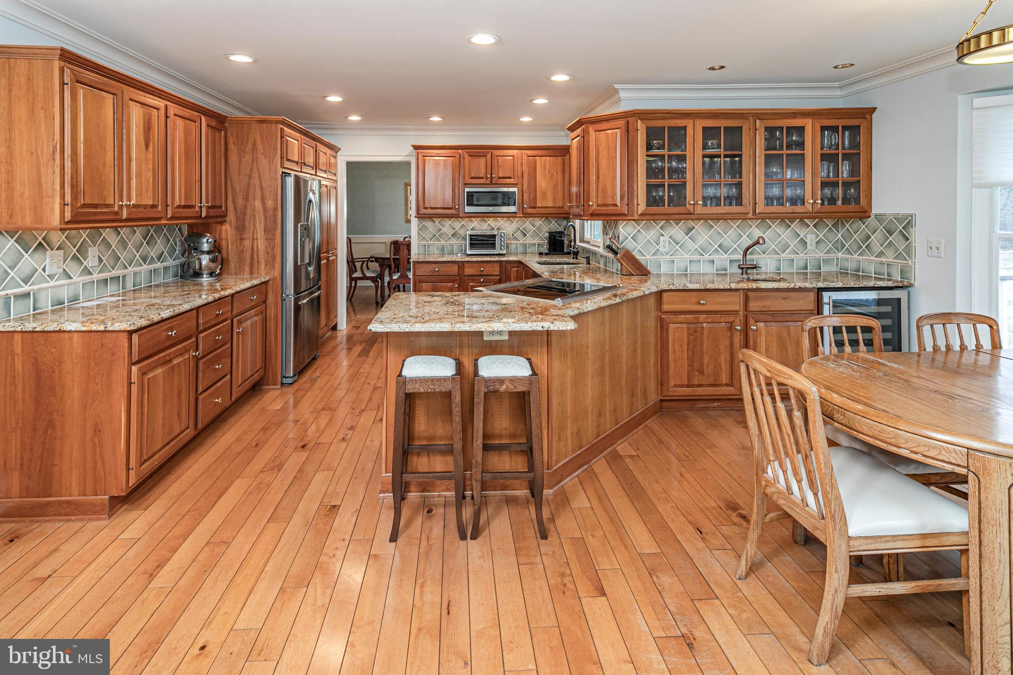6 Nelson Ridge Road Princeton, NJ 08540 - Photo 14 of 41 a kitchen with stainless steel appliances granite countertop a stove a sink dishwasher a microwave oven and a dining table with wooden floor