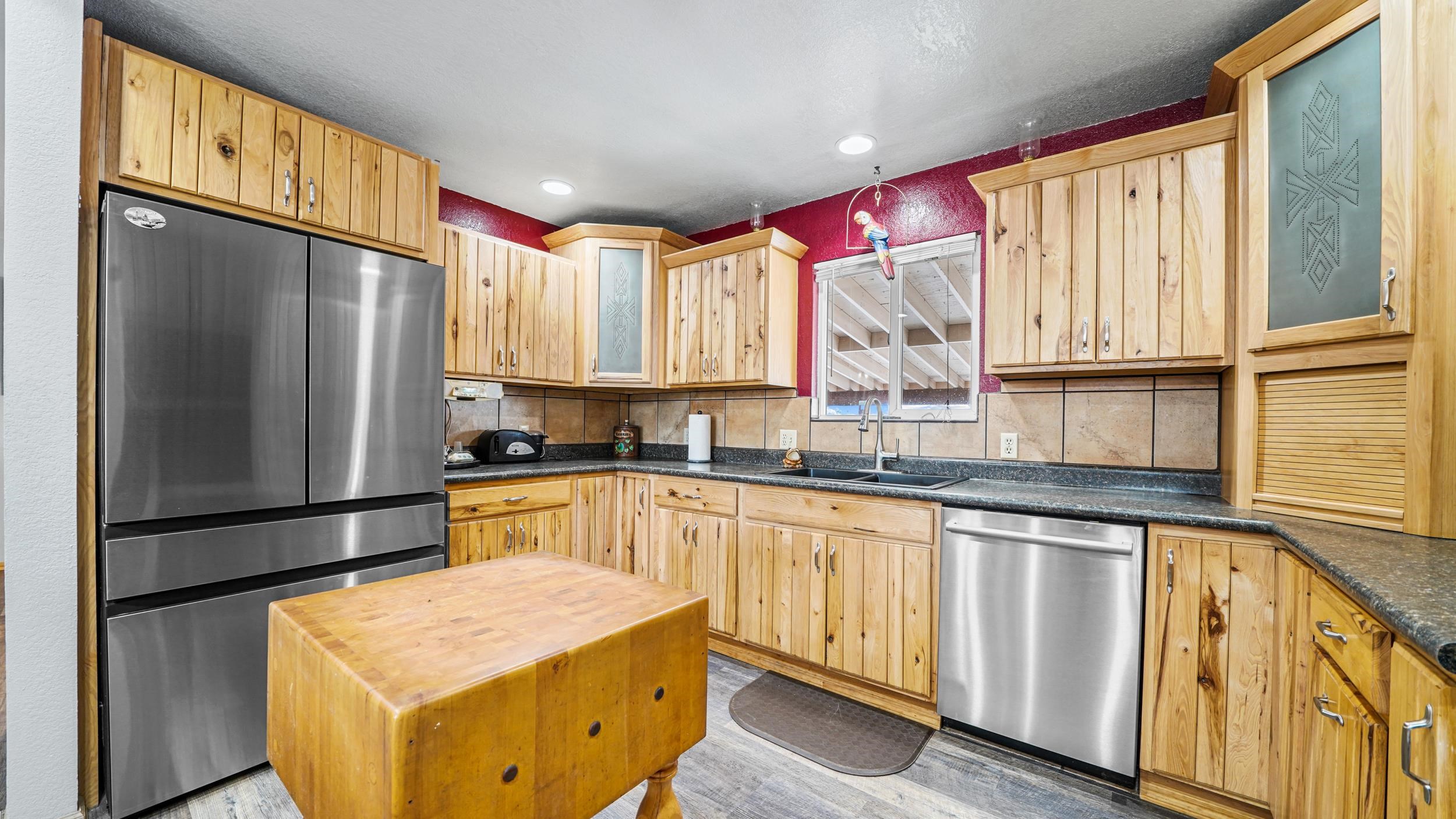 20786 Iris Road Austin, CO 81410 - Photo 12 of 38 a kitchen with stainless steel appliances granite countertop a refrigerator a sink dishwasher and wooden cabinets with a large window