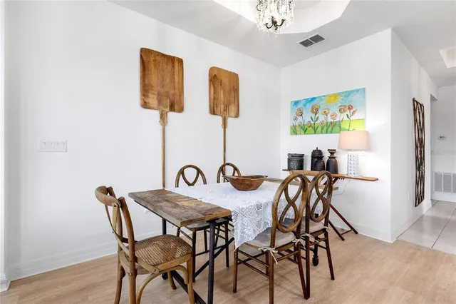 a kitchen with stainless steel appliances kitchen island granite countertop a refrigerator a stove a dining table and chairs