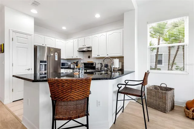 a kitchen with stainless steel appliances a sink a stove a refrigerator and cabinets