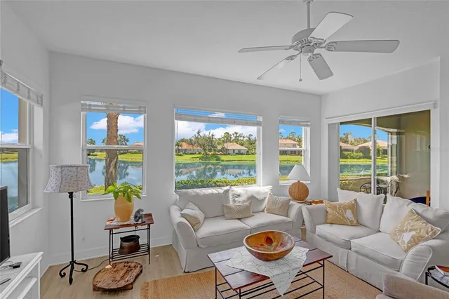 a living room with furniture a flat screen tv and a large window