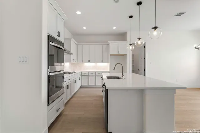 a kitchen with white cabinets and refrigerator