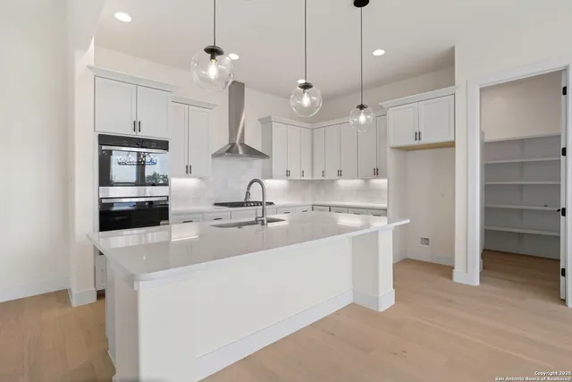 a large kitchen with cabinets a sink and a stove