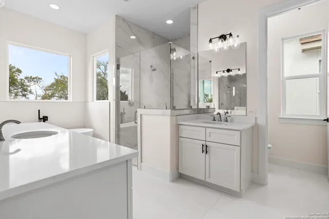 a spacious bathroom with a double vanity sink a mirror and a bathtub