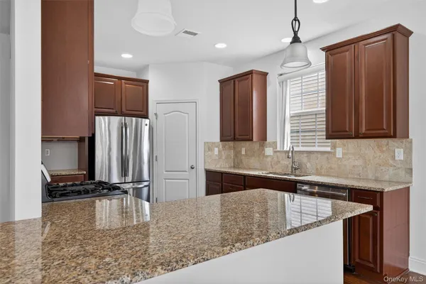 a kitchen with kitchen island granite countertop a sink appliances and cabinets