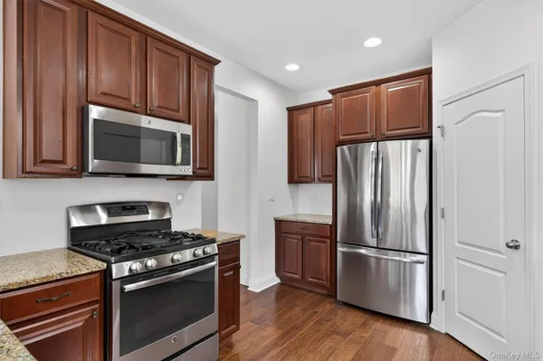 a kitchen with stainless steel appliances granite countertop a refrigerator stove and microwave