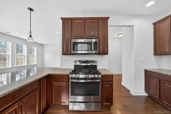 a kitchen with granite countertop a stove and a microwave