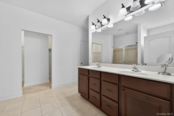 a bathroom with a double vanity sink mirror and cabinets