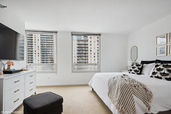 a bedroom with a bed a couch and large window