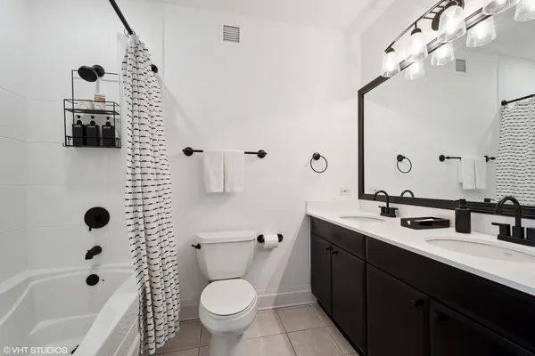 a bathroom with a double vanity sink toilet and shower