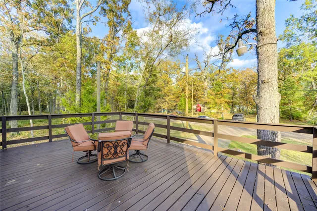 a roof deck with table and chairs and wooden floor