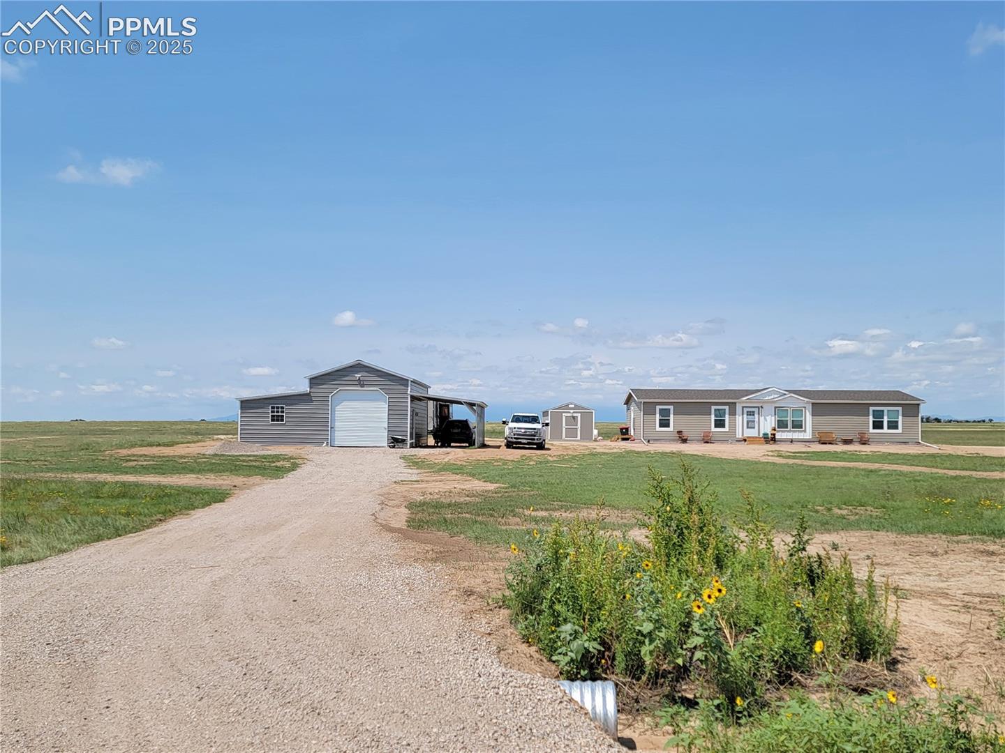 2950 East Ellicott Road South Calhan, CO 80808 - Photo 1 of 1 View of front of property featuring an outdoor structure, driveway, a detached garage, and a front yard