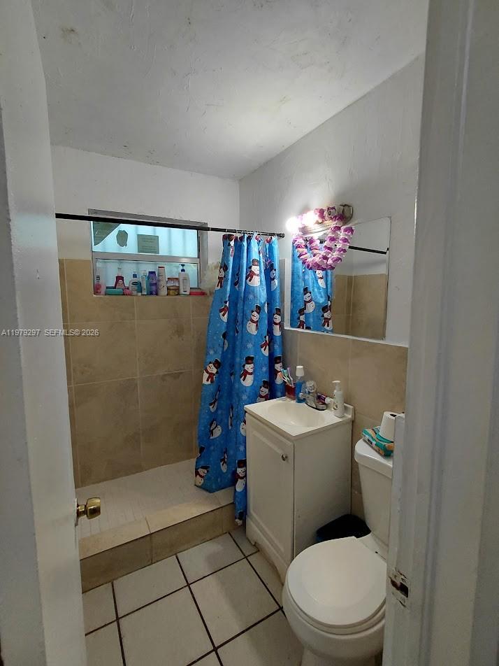 1262 Northwest 46th Street Miami, FL 33142 - Photo 7 of 11 a bathroom with a toilet a sink and mirror