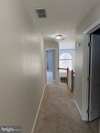 a view of a hallway with wooden shelves