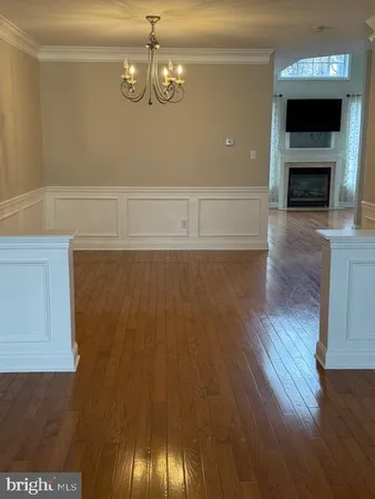 a view of empty room with wooden floor and fireplace