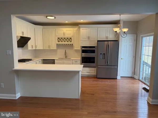 a kitchen with stainless steel appliances a refrigerator and a stove top oven