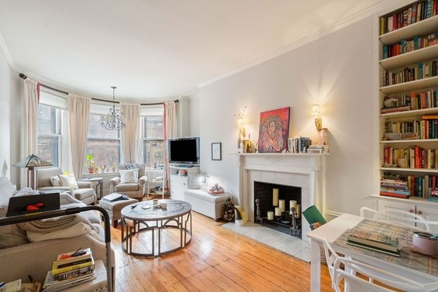 a living room with furniture a bookshelf and a fireplace