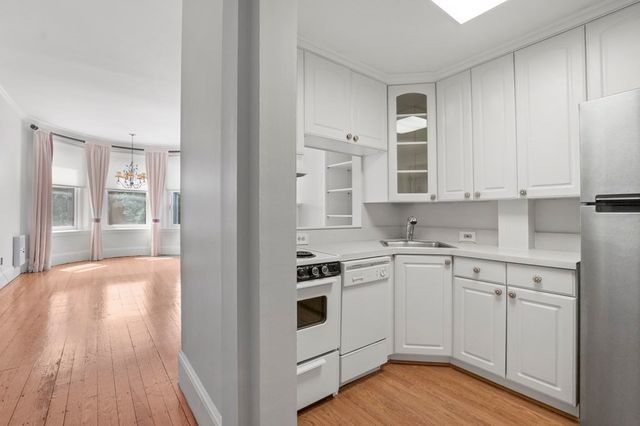 a kitchen with stainless steel appliances granite countertop a stove and white cabinets