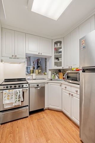 a kitchen with white cabinets and white appliances
