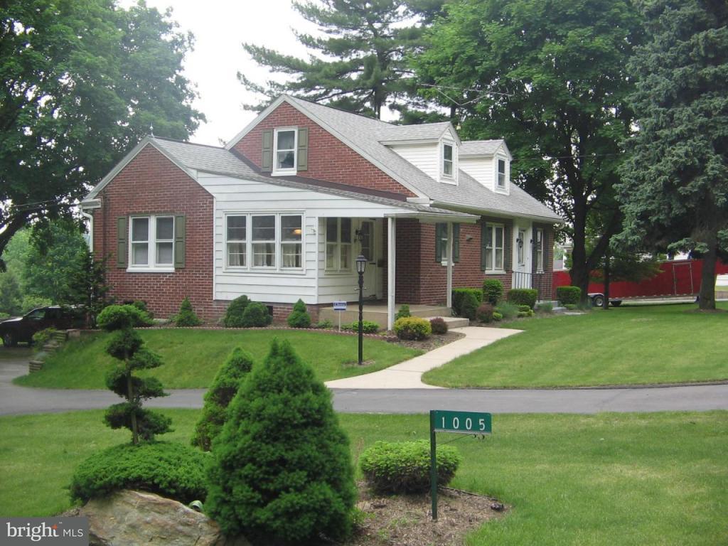 1005 Buck Road Quarryville, PA 17566 - Photo 3 of 11 a view of a brick house with a yard plants and large trees