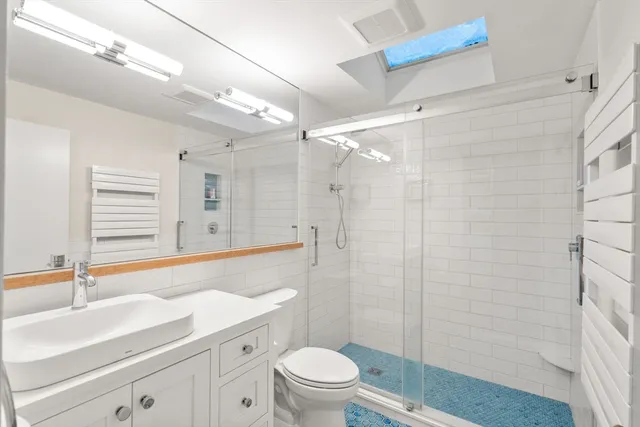 a bathroom with a toilet sink and mirror