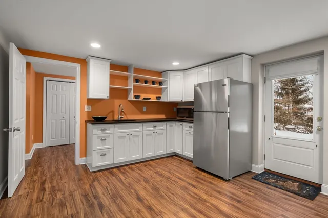 a view of a bedroom with wooden floor and window