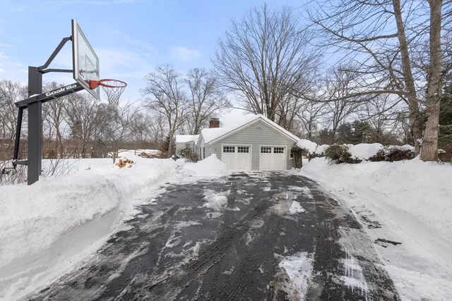 a front view of a house with a yard covered in snow