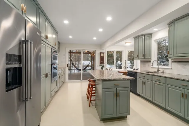 a kitchen with stainless steel appliances granite countertop a sink and a refrigerator