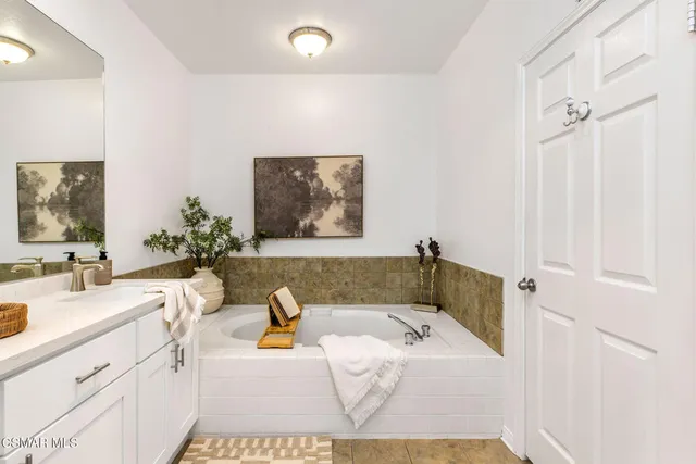 a bathroom with a tub sink and mirror