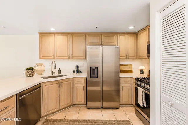 a kitchen with a sink a refrigerator and cabinets