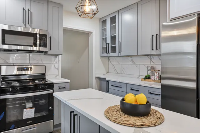 a kitchen with stainless steel appliances a stove a sink and a microwave