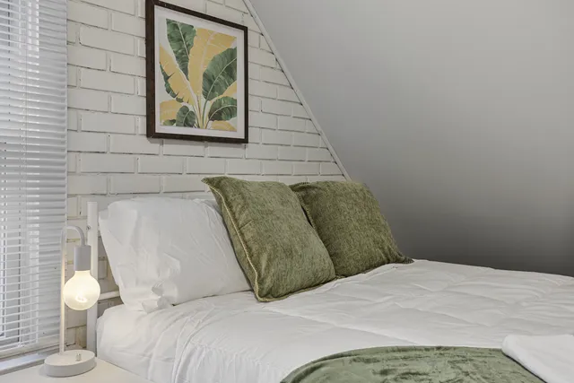 a bedroom with a bed and a painting on the wall