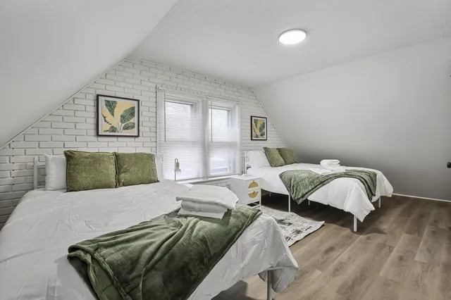 a bedroom with two beds and painting on the wall