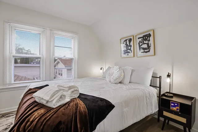 a bedroom with a bed and wooden floor