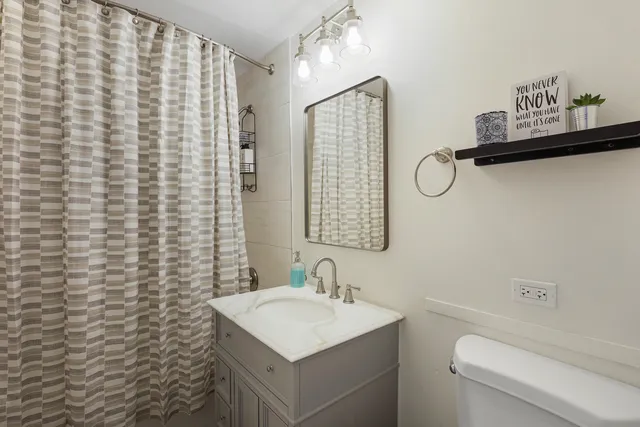 a bathroom with a sink a toilet and shower curtain