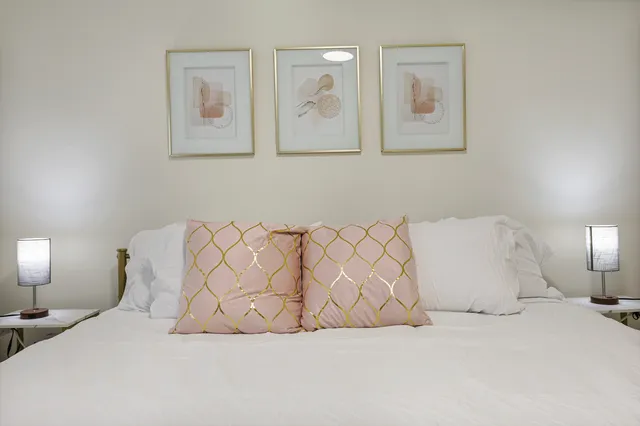 a large white bed sitting in a bedroom and lamp