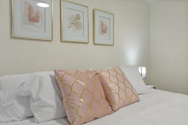 a bed with a white comforter and pillows