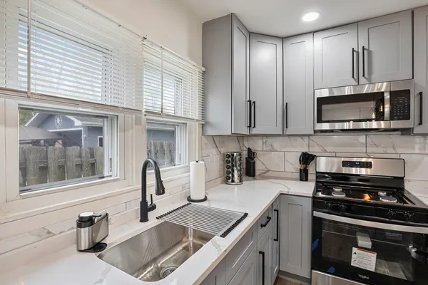 a kitchen with granite countertop a sink and steel appliances