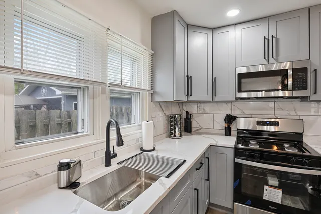 a kitchen with granite countertop a sink and steel appliances