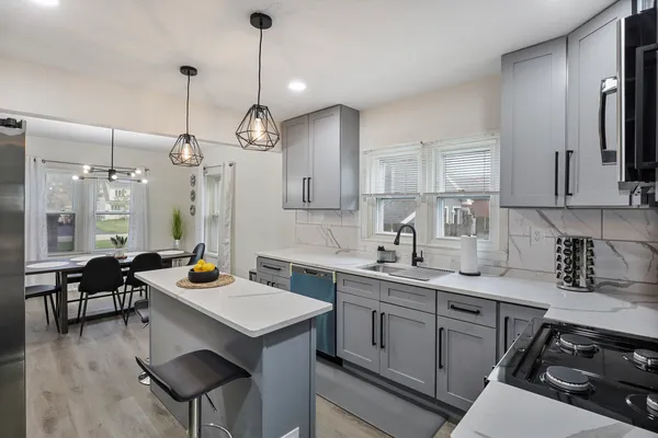 a kitchen with a sink a stove a refrigerator and chairs