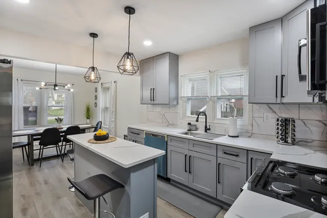 a kitchen with a sink a stove a refrigerator and chairs