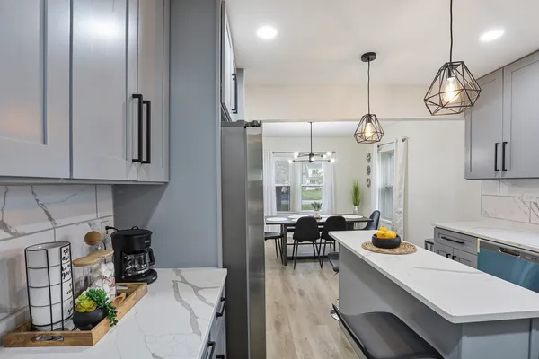 a room with stainless steel appliances kitchen island granite countertop furniture a stove a sink and a refrigerator