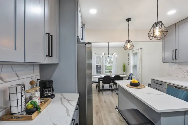 a room with stainless steel appliances kitchen island granite countertop furniture a stove a sink and a refrigerator