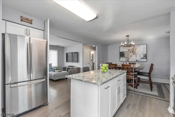 a dining room with furniture a chandelier and kitchen view