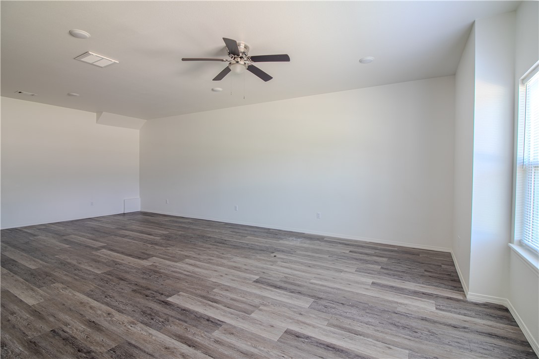 803 South Rupple Road, Unit 1 Fayetteville, AR 72704 - Photo 6 of 22 Spacious room featuring wood-finish flooring, a ceiling fan, recessed lighting, and a window with blinds