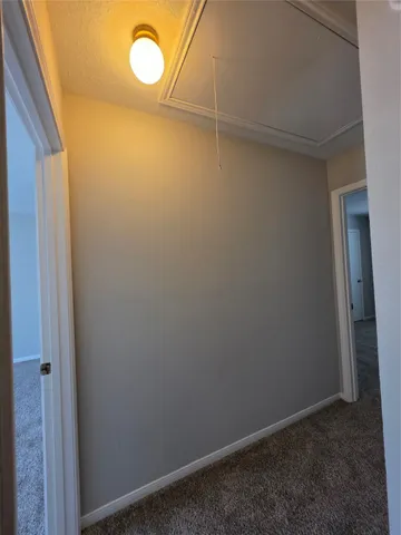 a view of an empty room with a chandelier fan