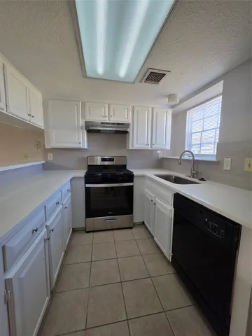 a kitchen with a sink dishwasher a stove and a microwave oven
