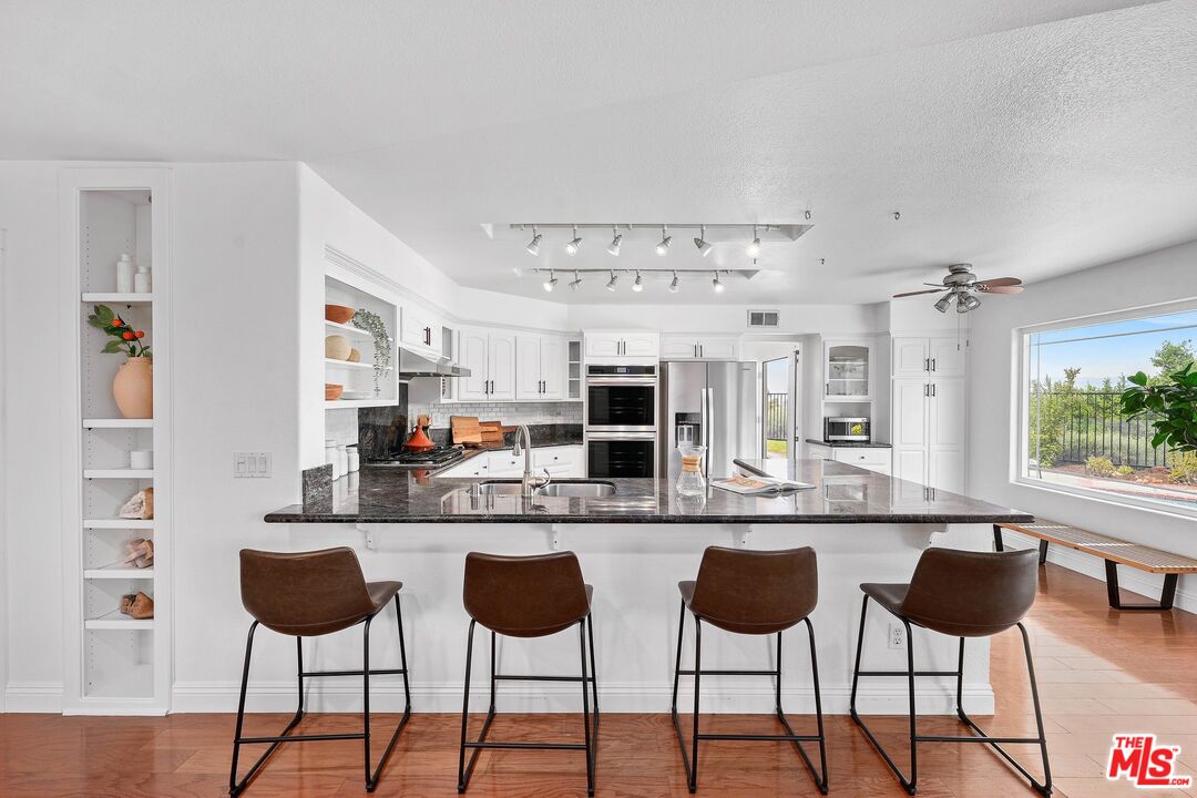 24006 Briardale Way Newhall, CA 91321 - Photo 12 of 34 a kitchen with granite countertop a dining table and chairs