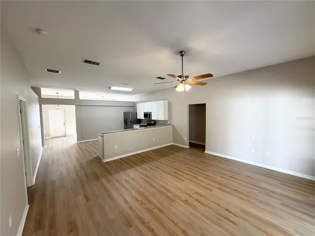 a view of a living room a kitchen and a wooden floor